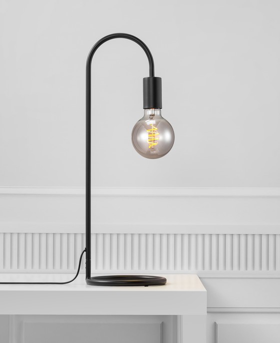 Stolová dekoratívna lampička Paco od Nordluxu v čiernom dizajne. Ideálna v kombinácii s dekoratívnou žiarovkou do čitateľského kútika alebo spálne.