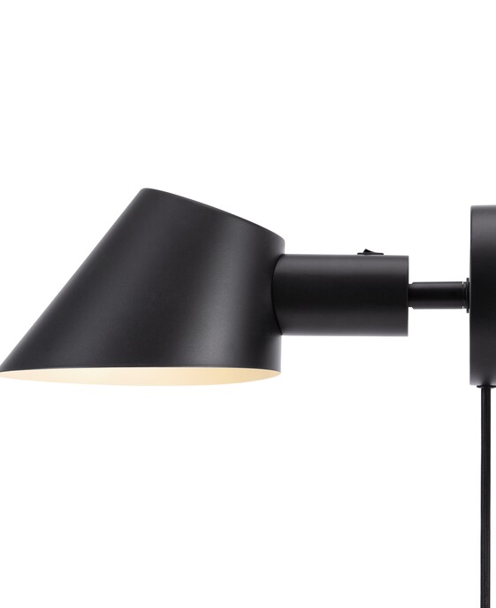 Nástenná lampa Stay Short od Nordluxu s nastaviteľnou hlavou v zošikmenom tvare.