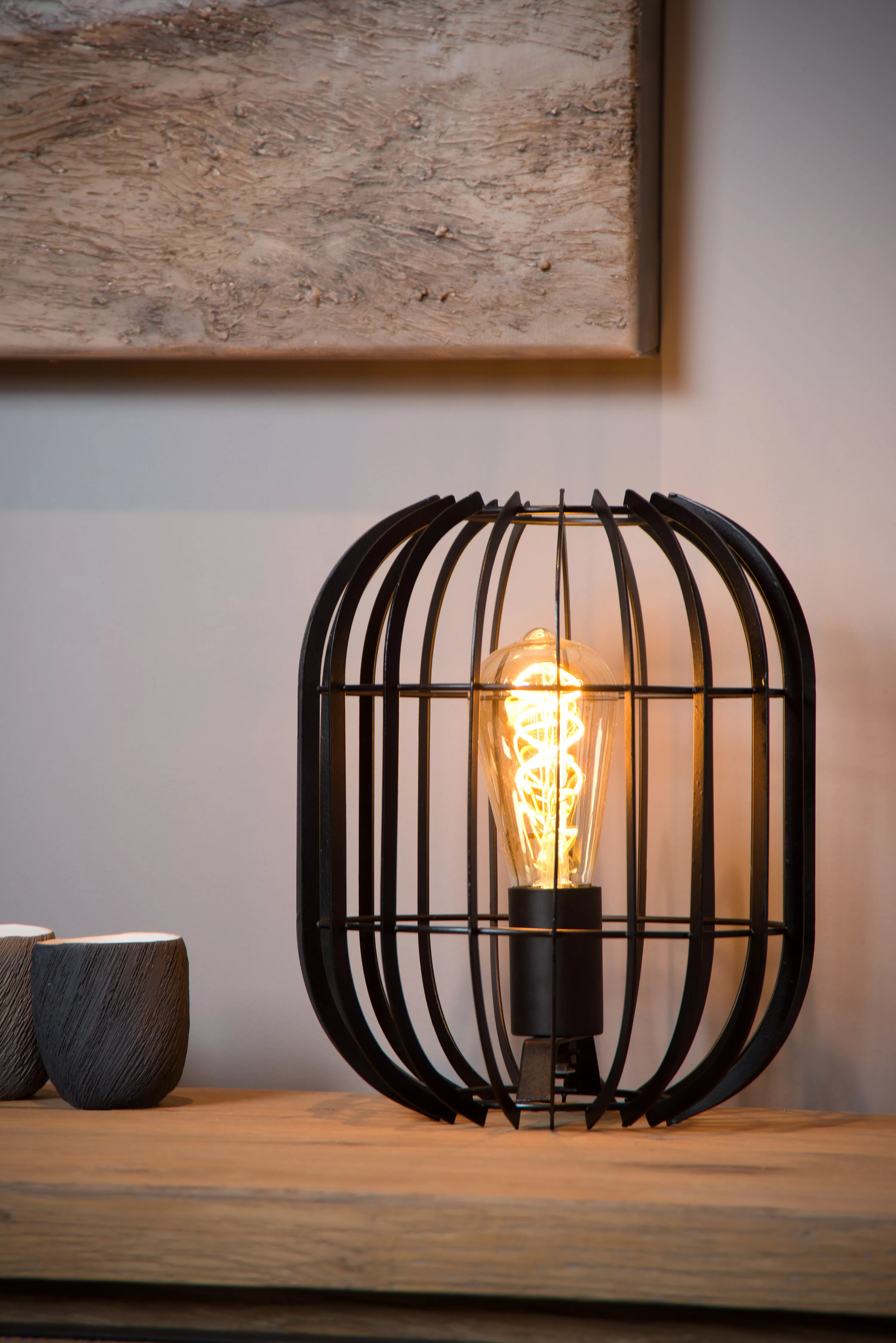 Jednoduchá kovová stolová lampička Reda sa hodí do moderného interiéru a vytvára príjemnú hru svetla na stenách.