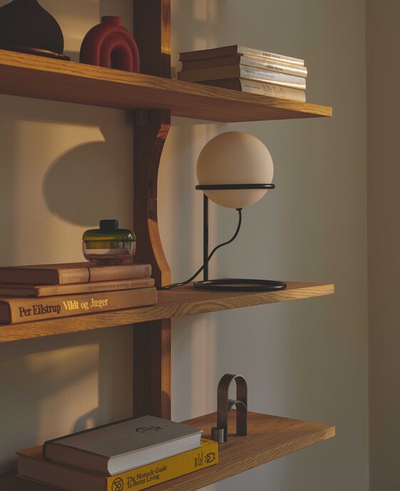 Stolová lampička Wilson s čiernym kovovým rámom a skleneným tienidlom osvetlí kútik na čítanie alebo spálňu príjemným mäkkým svetlom. Tienidlo možno polohovať.